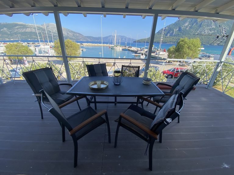Covered balcony with dining table overlooking Mytikas harbour, upper sea-view apartment, Aphrodite Apartments Mytikas